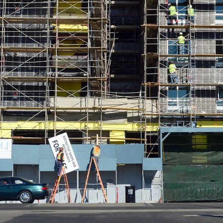 Pedestrians cross the street as construction workers work on the exterior of a commercial and residential building going up in Hollywood, California on January 22, 2014.  US housing starts dived almost 10 percent in December from a five-year high but maintained robust growth for the year as the housing market recovers,  government data showed last week, as new residential construction fell to a seasonally adjusted annual rate of 999,900 in December. The full year 2013 data underlined the strength of last year's housing market recovery following the 2006 collapse of a price bubble. AFP PHOTO/Frederic J. BROWN        (Photo credit should read FREDERIC J. BROWN/AFP/Getty Images)