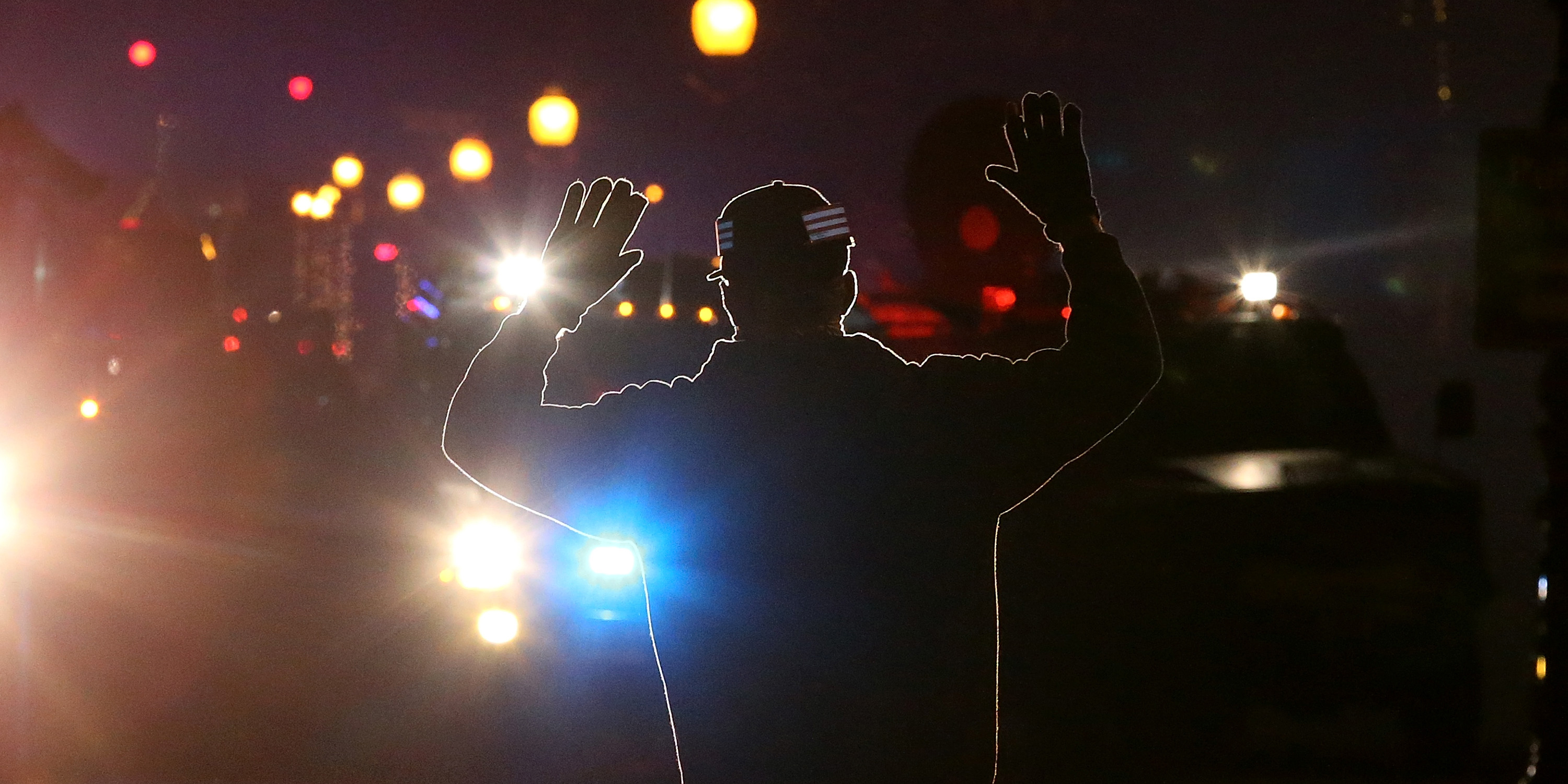 FERGUSON, MO - NOVEMBER 24:  A protester stands in front of police vehicles with his hands up during a demonstration on November 24, 2014 in Ferguson, Missouri. A St. Louis County grand jury has decided to not indict Ferguson police Officer Darren Wilson in the shooting of Michael Brown that sparked riots in Ferguson, Missouri in August.  (Photo by Justin Sullivan/Getty Images)