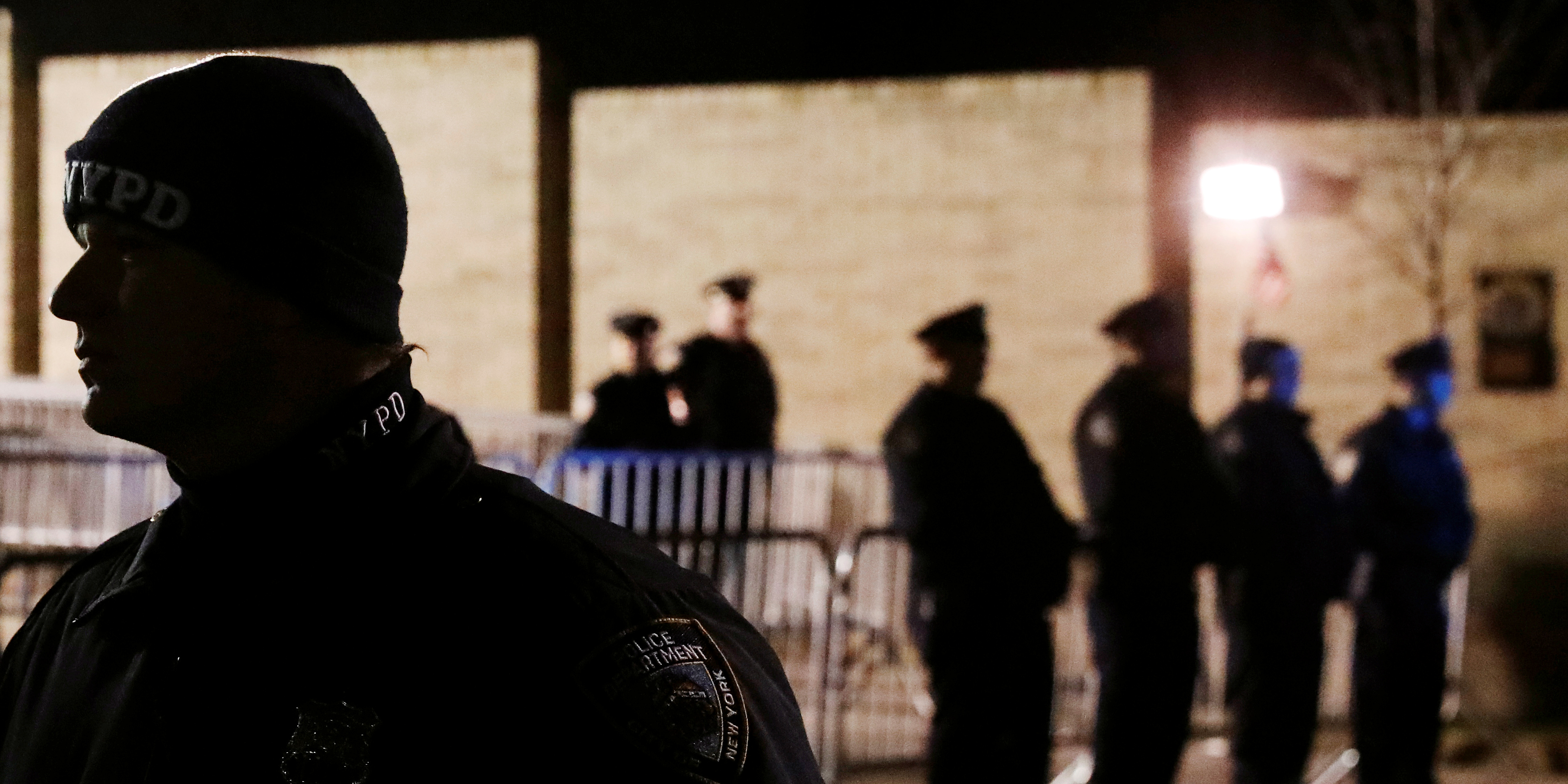 New York Police Department (NYPD) officers stand outside of their precinct to watch as demonstrators protest the killing of Saheed Vassell by NYPD officers in the Brooklyn borough of New York, U.S., April 5, 2018. REUTERS/Lucas Jackson - RC16C3E2FB40