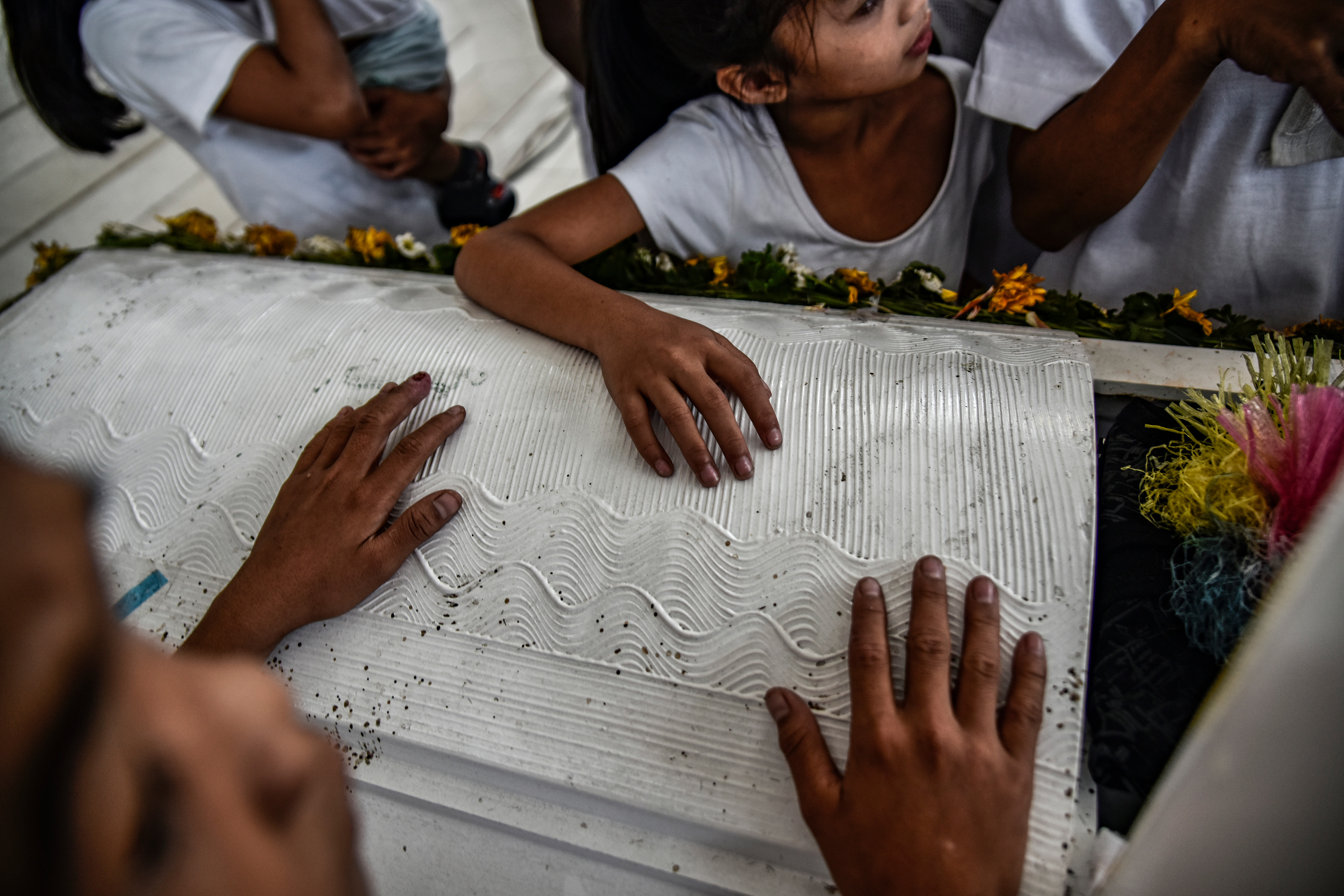 Children hold the coffin of 13-year-old Aldrin Pineda, who was shot to death by a police officer, during his funeral in Manila, Philippines, March 14, 2018. More than 27,000 have been killed as a result of a two-year war on drugs in the Philippines. In 2016, Rodrigo Duterte became president of the Southeast Asian republic. His campaign promise to fight drugs with any means won him the election: he threatened those connected to the drug trade with death, called for vigilante justice, and allowed the police to act with brutality. Human rights groups and local media have reported that dealers, users, petty criminals, and even local politicians, priests, as well as plenty of innocent people and children were murdered. The United Nations have appealed in vain to the Philippine government to investigate extrajudicial killings and to prosecute the perpetrators, while the International Criminal Court has begun preliminary inquiries into the violent acts carried out in the Philippines as well as the questionable methods of Duterte and the police.Photo: Ezra Acayan/NurPhoto (Photo by Ezra Acayan/NurPhoto via Getty Images)
