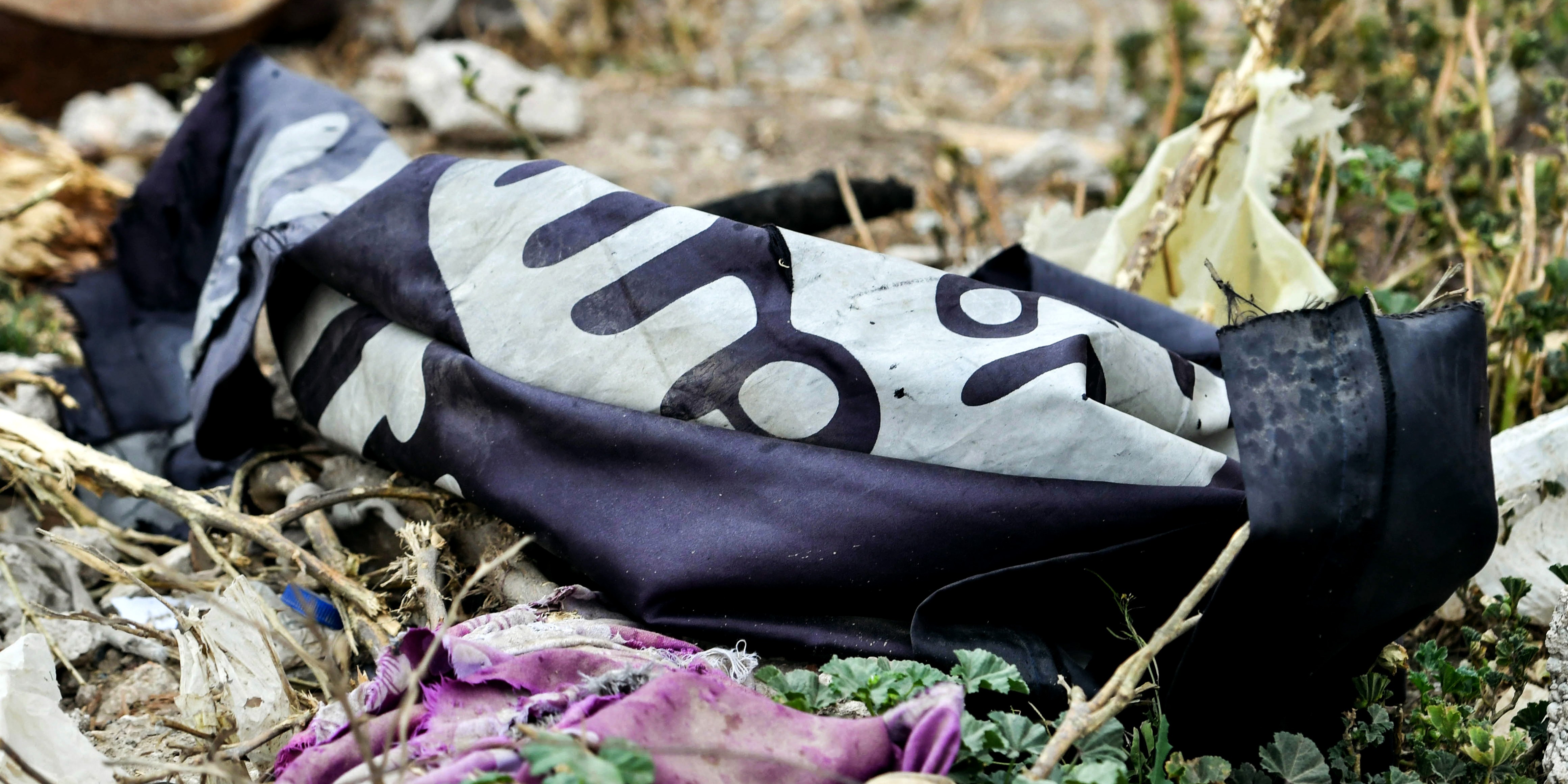 A discarded Islamic State flag on the ground in the village of Baghouz in Syria's eastern Deir Ezzor province on March 24, 2019, one day after ISIS was declared "defeated" by the U.S.-backed Syrian Democratic Forces.