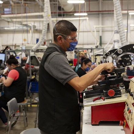 A worker wearing a protective mask operates machinery at the Standex Electronics manufacturing facility in Agua Prieta, Sonora state, Mexico, on Monday, April 27, 2020. Standex Electronics Inc., which designs parts for medical equipment such as CT scanners and x-ray machines, as well as components used in the utility grid and the defense industry, reopened its Sonora facility at roughly one-third of its capacity and with strict social-distancing rules in place. Photographer: Cheney Orr/Bloomberg via Getty Images