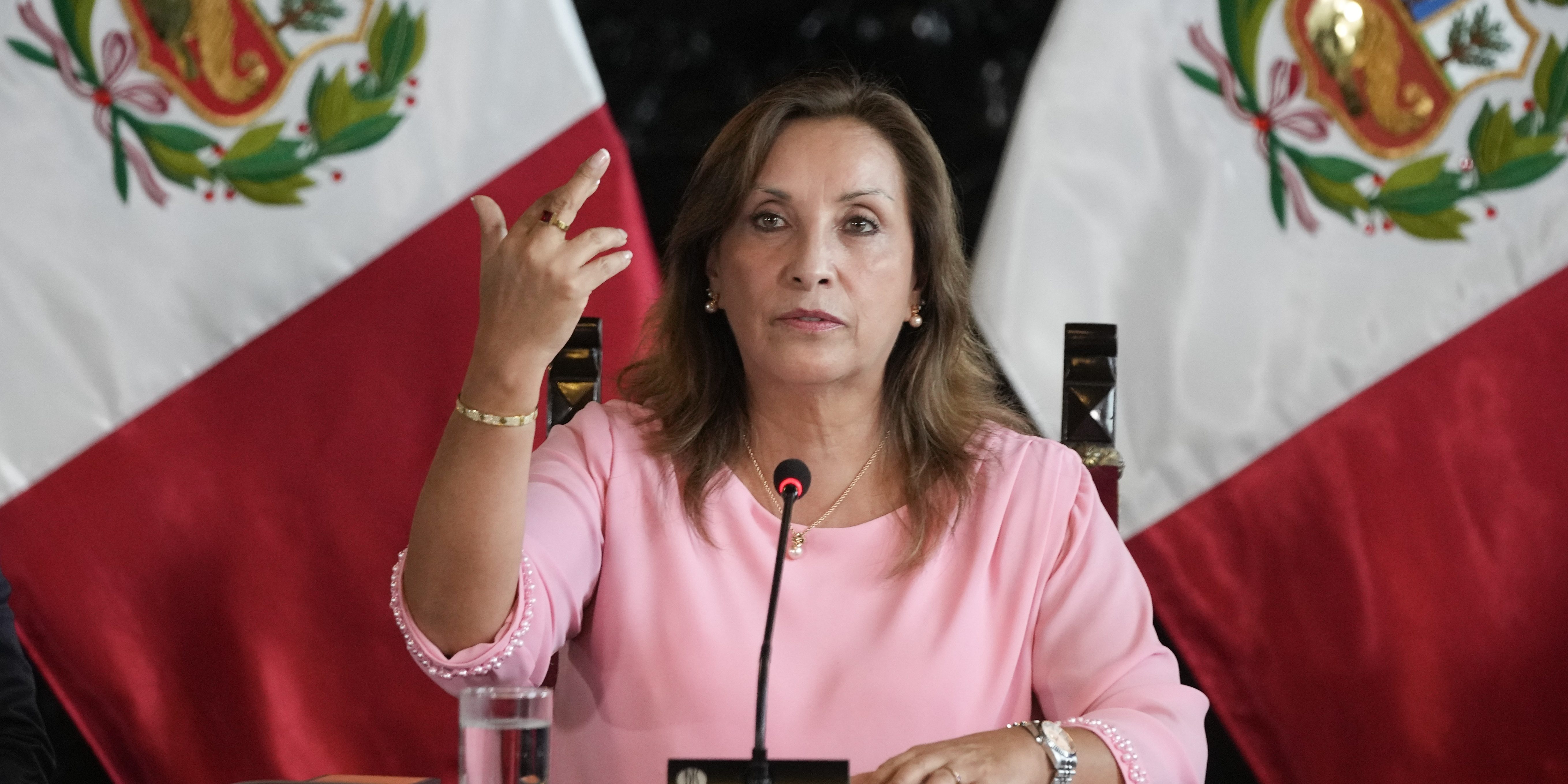 Peru's President Dina Boluarte holds up her hand to show the ring and bracelet she is wearing, during a press conference at Government Palace, in Lima, Peru, Friday, April 5, 2024. She has been accused of illegally receiving cash, luxury watches and jewelry.