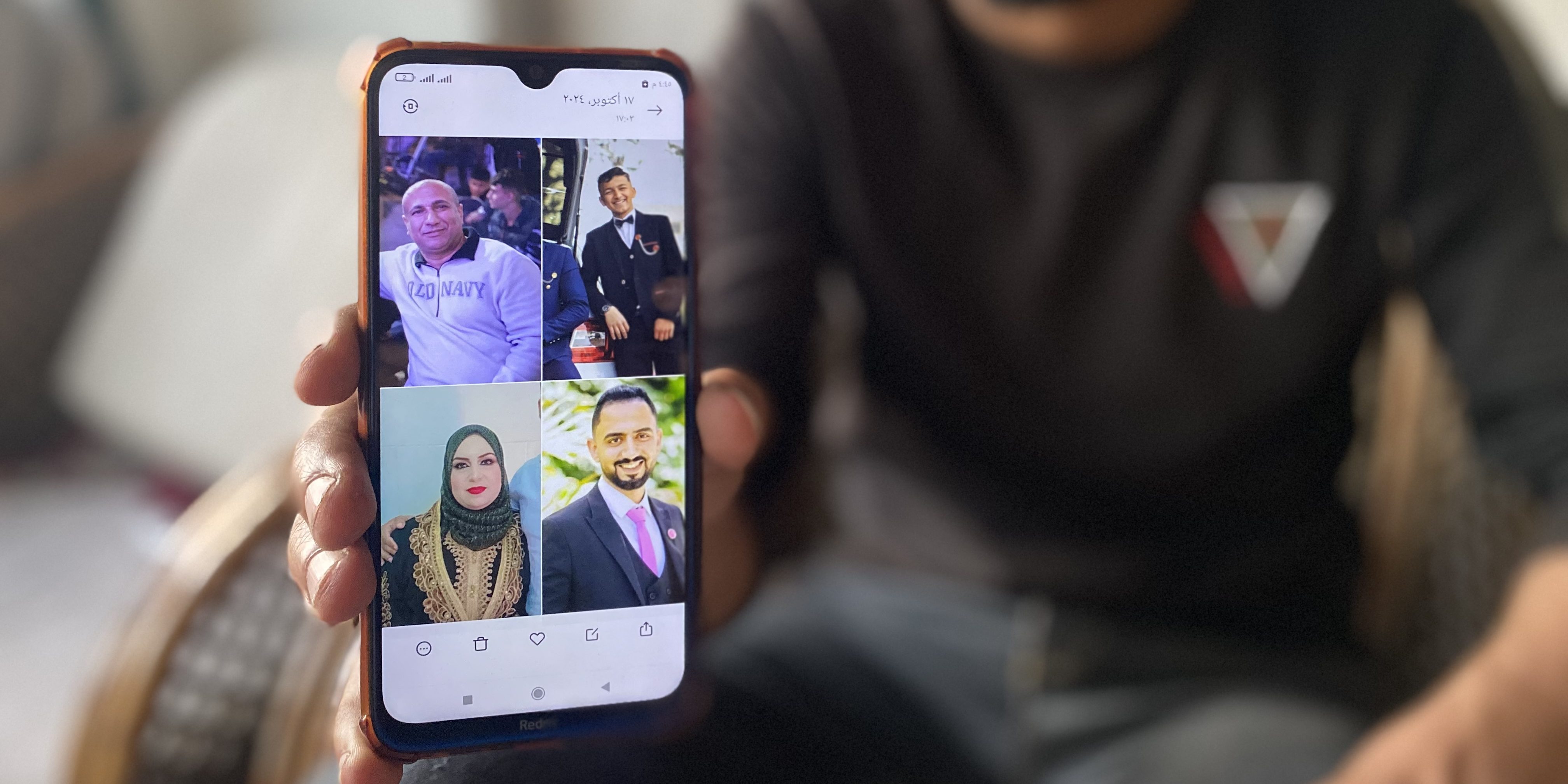 Ramez Abu Nasser mostra le foto dei suoi genitori e dei suoi due fratelli, uccisi in un attacco israeliano il 4 novembre 2024.