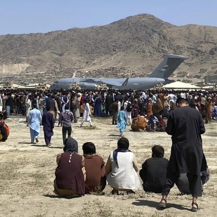 Hundreds of people gather near a U.S. Air Force C-17 transport plane at the perimeter of the international airport in Kabul, Afghanistan, Aug. 16, 2021.