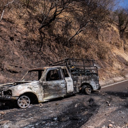 A burnt truck is pictured after a wave of violence in the town of Aguililla, the birthplace of drug kingpin Nemesio Oseguera, leader of the Jalisco New Generation Cartel (CJNG) in Tierra Caliente, Mexico, on February 24, 2026. Mexican President Claudia Sheinbaum on February 24 dismissed risks to fans visiting Guadalajara, one of the venues for the 2026 World Cup, after a drug cartel riot caused fear in the city and much of the country on February 22. (Photo by Enrique Castro / AFP via Getty Images)