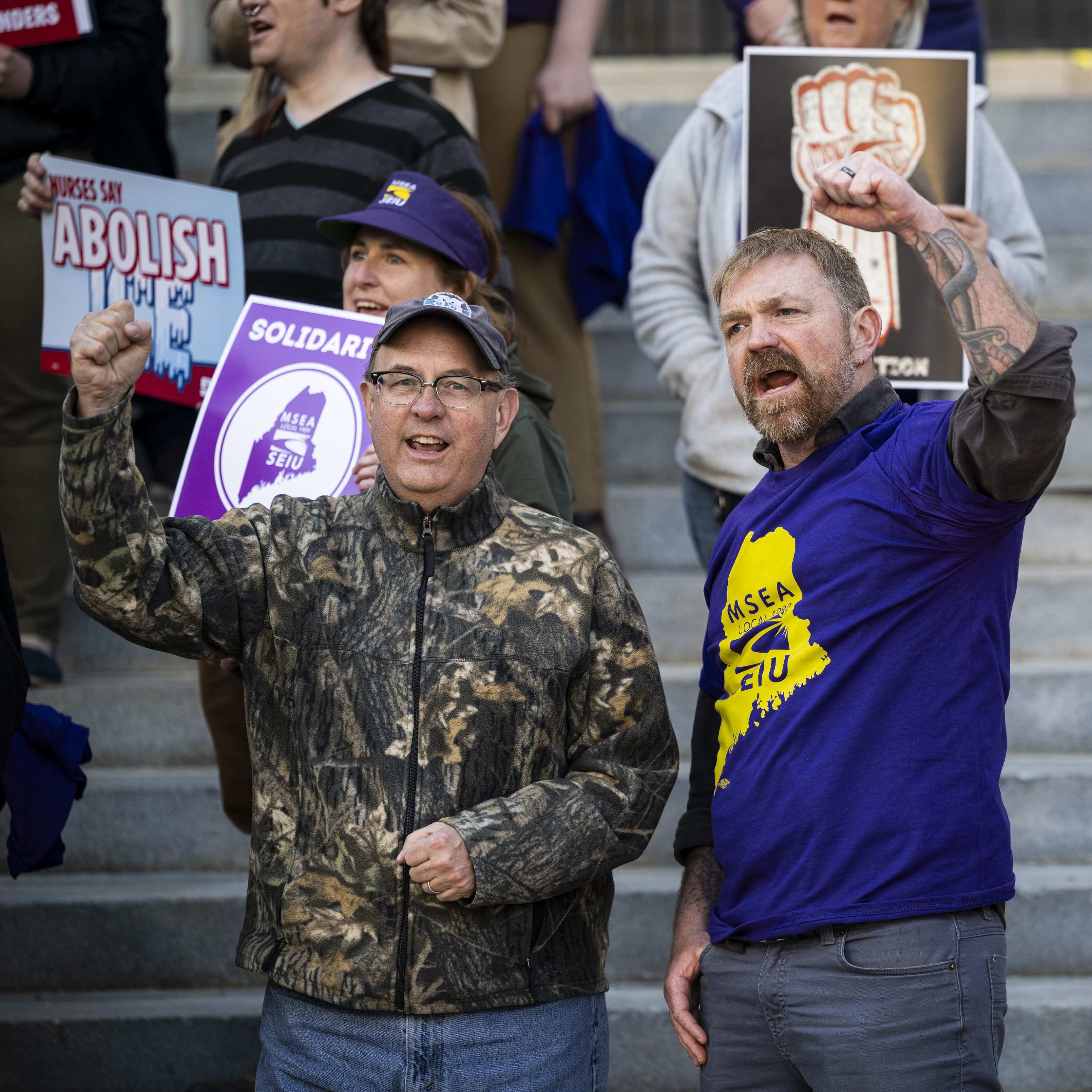 PORTLAND, MAINE - MAY 1: U.S. House candidate from Maine Matt Dunlap (L) and U.S. Senate candidate from Maine Graham Platner (C) cheer during a May Day rally organized by local unions, on May 1, 2026 outside City Hall in Portland, Maine. Platner joined the Maine Service Employees Association SEIU 1989 demonstration to honor the labor rights movement as he campaigns to be the Democratic nominee ahead of the June primary. (Photo by Graeme Sloan/Getty Images)