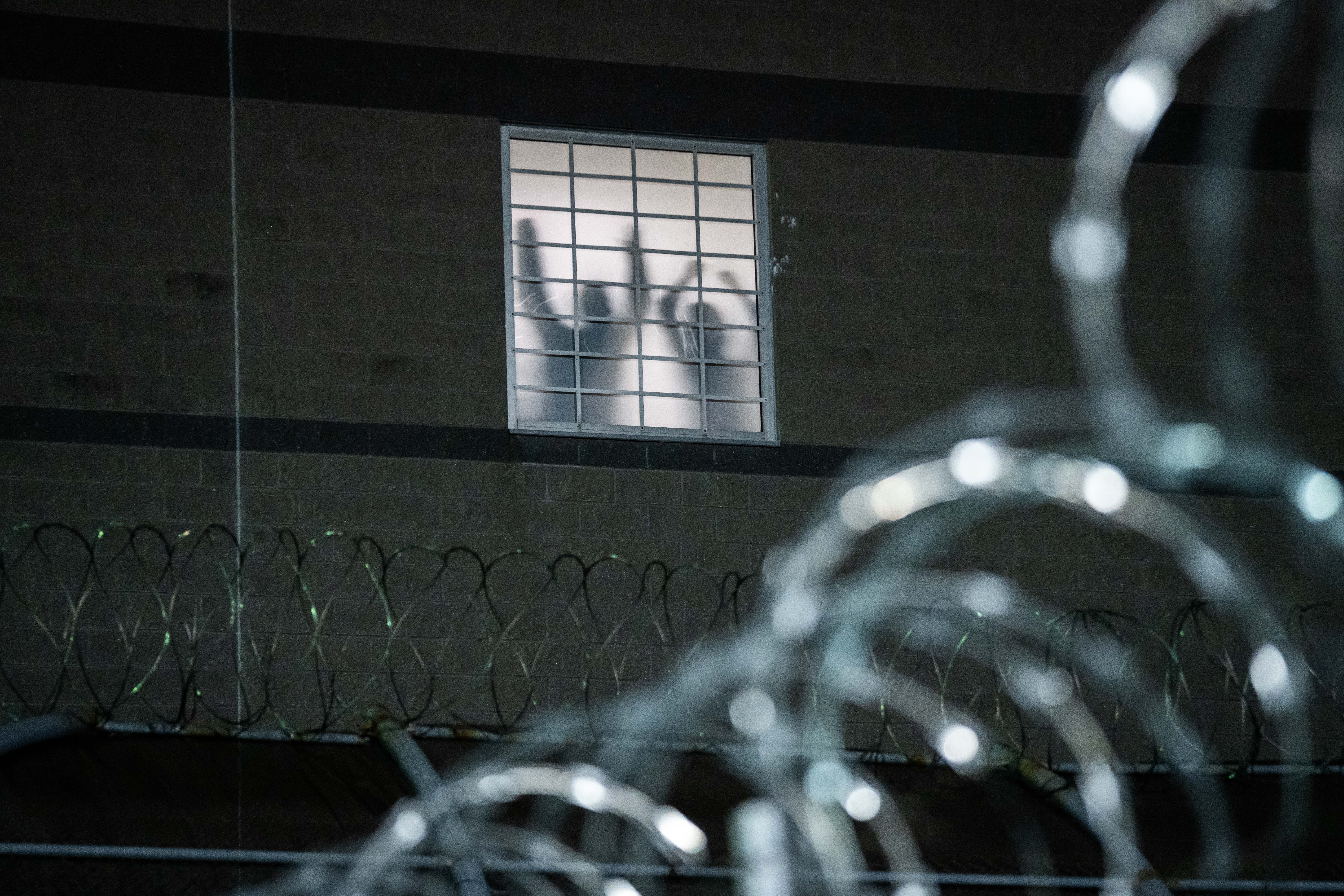 NEWARK, NEW JERSEY - MAY 26: Detainees stand by a window inside the federal immigration center at Delaney Hall in Newark, where ICE is housing detained immigrants on May 26, 2026 in Newark, New Jersey. The protests, which have become tense over the holiday weekend, come amid reports of an ongoing hunger strike by detainees. (Photo by Adam Gray/Getty Images)