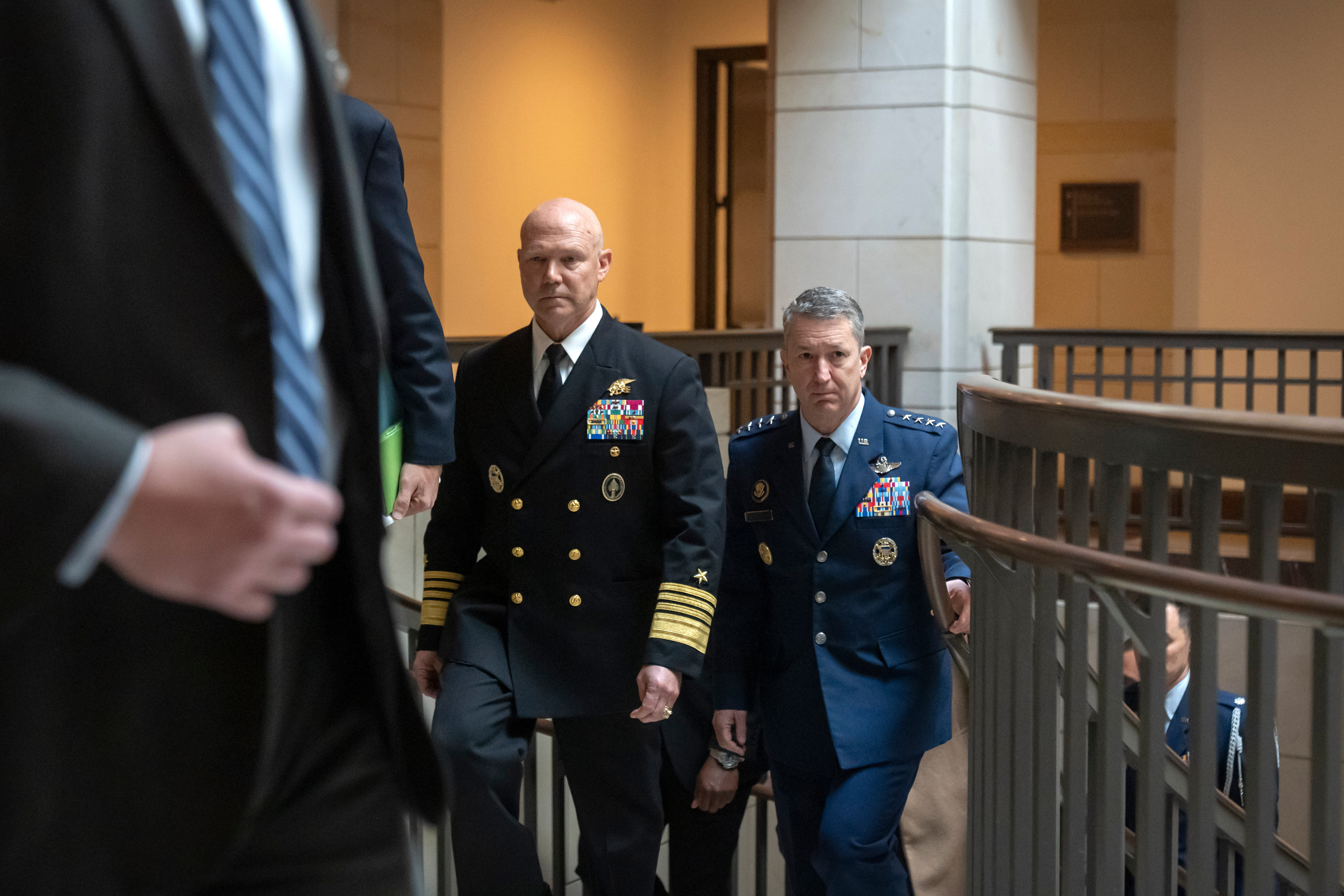 U.S. Navy Adm. Frank M. Bradley, accompanied by Gen. Dan Caine, chairman of the Joint Chiefs of Staff, right, walks to a meeting with senators on Capitol Hill, Thursday, Dec. 4, 2025, in Washington. (AP Photo/Mark Schiefelbein)