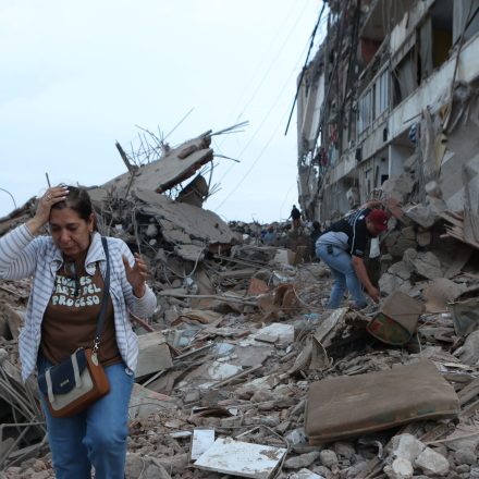 Residents walk among the rubble of building damaged in earthquakes the previous day in Catia La Mar, Venezuela, Thursday, June 25, 2026.