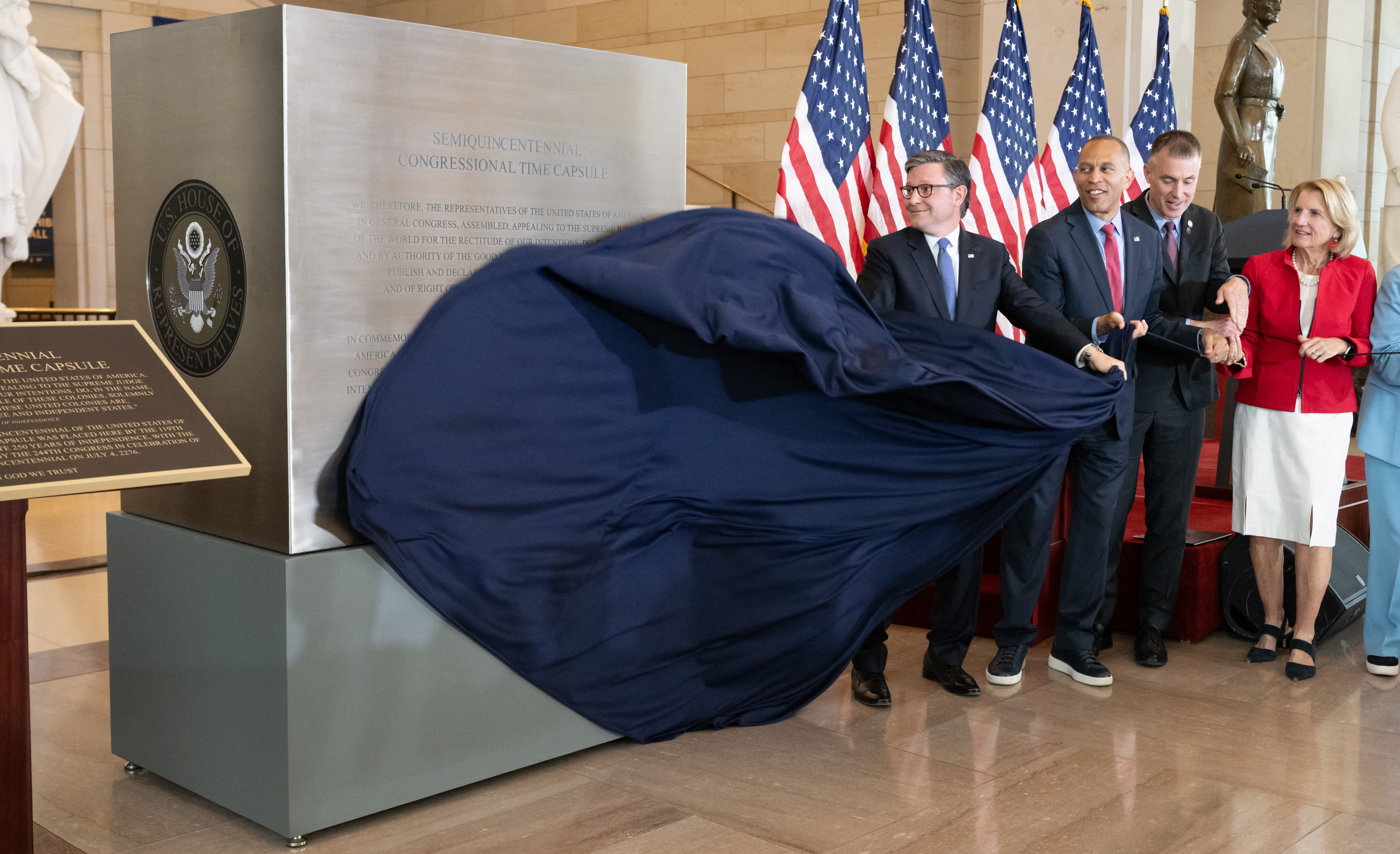 US Speaker of the House Mike Johnson and US House Minority Leader Hakeem Jeffries unveil the Semiquincentennial Congressional Time Capsule in honor of the 250th birthday of the United States to be opened on the 500th anniversary of the founding of the United States, during a ceremony in Emancipation Hall at the US Capitol in Washington, DC, on June 24, 2026. The capsule, that will be buried at the Independence National Historical Park in Philadelphia on July 4, features contributions from all 50 states, US territories and federal partners. Artifacts include state-specific mementos, student artwork, an Olympic gold medal, and a letter from living presidents. (Photo by SAUL LOEB / AFP via Getty Images)