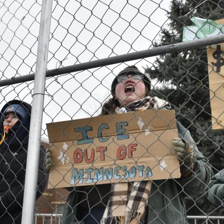 Demonstrators against US Immigration and Customs Enforcement (ICE) stand behind a fence outside the Bishop Whipple Federal Building where federal agents are operating, following last weeks fatal shooting of 37-year-old ICU nurse Alex Pretti by ICE agents during a federal immigration enforcement operation in Minneapolis, Minnesota, on January 26, 2026. On January 24, federal agents shot and killed Alex Pretti, a 37-year-old ICU nurse, while scuffling with him on an icy roadway in Minneapolis, less than three weeks after an immigration officer fired on Renee Good, also 37, killing her in her car. US President Donald Trump blamed their deaths on Democratic "chaos," as his administration faced intensifying pressure over its mass immigration crackdown in Minneapolis. (Photo by Octavio JONES / AFP via Getty Images)
