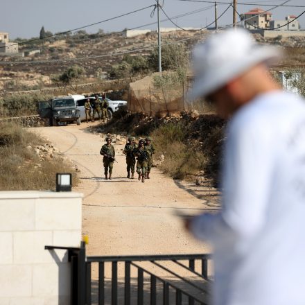 QUSRA, WEST BANK, PALESTINE - AUGUST 20: Israeli army soldiers patrol as Palestinian residents remain confined inside their homes in the village of Qusra, south of Nablus in the West Bank, on August 20, 2026, after the Israeli military declared three residential properties a 'closed military zone' following repeated attacks and blockade by Israeli settlers. The restrictions began on Aug. 9, when settlers surrounded the homes and limited residents' movement and access to food, water and electricity. The 13-day blockade, which affects a home owned by Palestinian-American Loui Ridi, has drawn international attention, leading U.S. Ambassador to Israel Mike Huckabee, a long-time supporter of West Bank settlements, to issue a rare statement condemning the actions of the extremist settlers and describing them as 'terrorists' as local families appeal for an immediate end to the military isolation. Ridi said Huckabee's remarks were a positive step but had not changed conditions on the ground, and called on the US government to provide protection for him and his family. (Photo by Issam Rimawi/Anadolu via Getty Images)