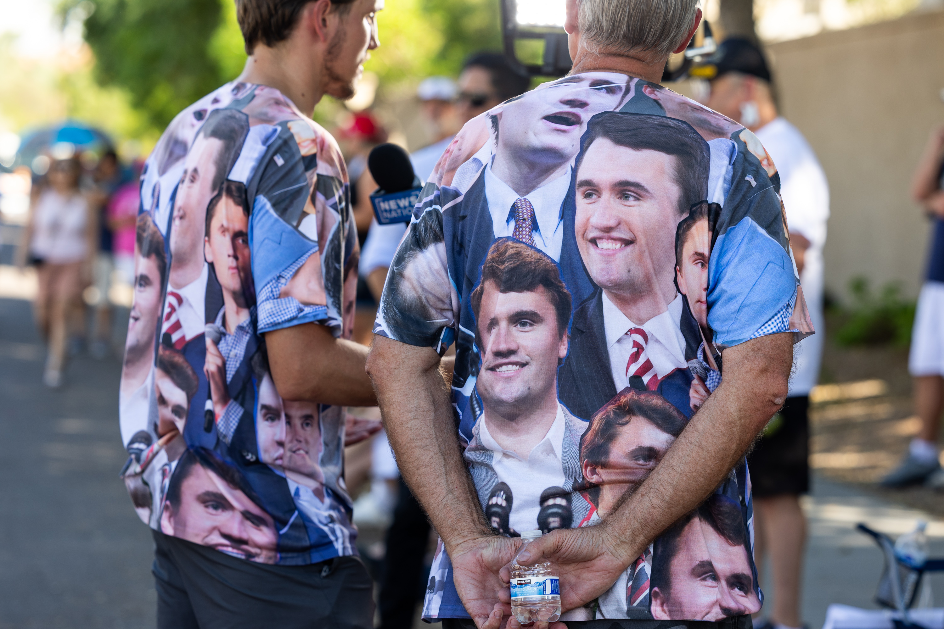 PHOENIX, ARIZONA - SEPTEMBER 20: People wearing T-shirts featuring Charlie Kirk stand outside the Turning Point USA's Phoenix headquarters to commemorate the conservative activist on September 20, 2025 in Phoenix, Arizona. As tens of thousands of people poured into Phoenix this weekend to attend Mr. Kirk's memorial service at the city's N.F.L. stadium on Sunday. (Photo by Qian Weizhong/VCG via Getty Images)