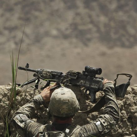 A United States Army soldier from Bravo Company, 2nd Battalion of the 508 Parachute Infantry Regiment of the 82nd Airborne, climbs over a high wall during a patrol in the volatile Arghandab Valley, outside Kandahar City, Saturday, July 10, 2010.
