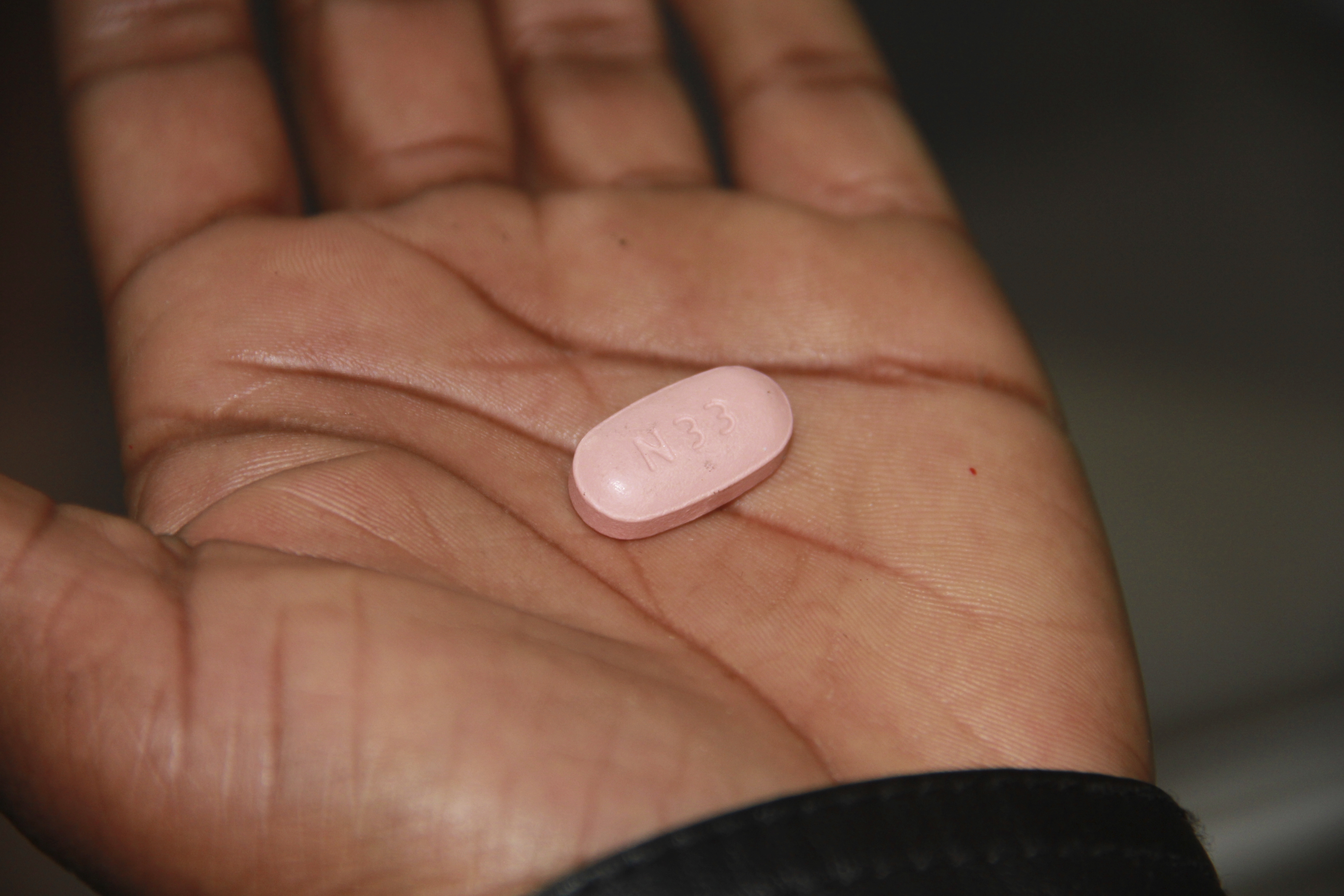 A 36-year-old HIV-positive sex worker and mother of one who requested anonymity, shows a antiretroviral drug bought illegally on the blackmarket in Johannesburg, South Africa, Friday, June 20, 2025. (AP Photo/Louise Dewast)